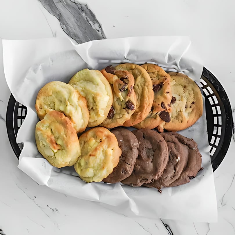 A basket of Sumah Hot Chicken cookies, including chocolate chip, white chocolate macadamia, and double chocolate.